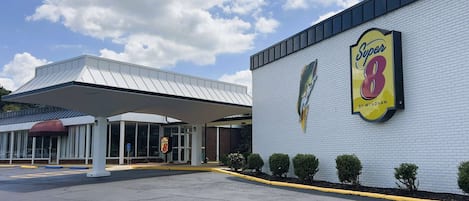 A Super 8 hotel with a large sign, a covered entrance, and a parking lot.