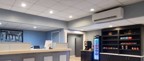 A reception area with a counter, a refrigerator stocked with beverages, and a display of snacks.