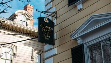 A sign for Curwen House of the Salem Inn, indicating a historical building with classical architectural features.