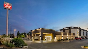 Un hôtel avec une enseigne bien visible, une entrée abritée et un parking.