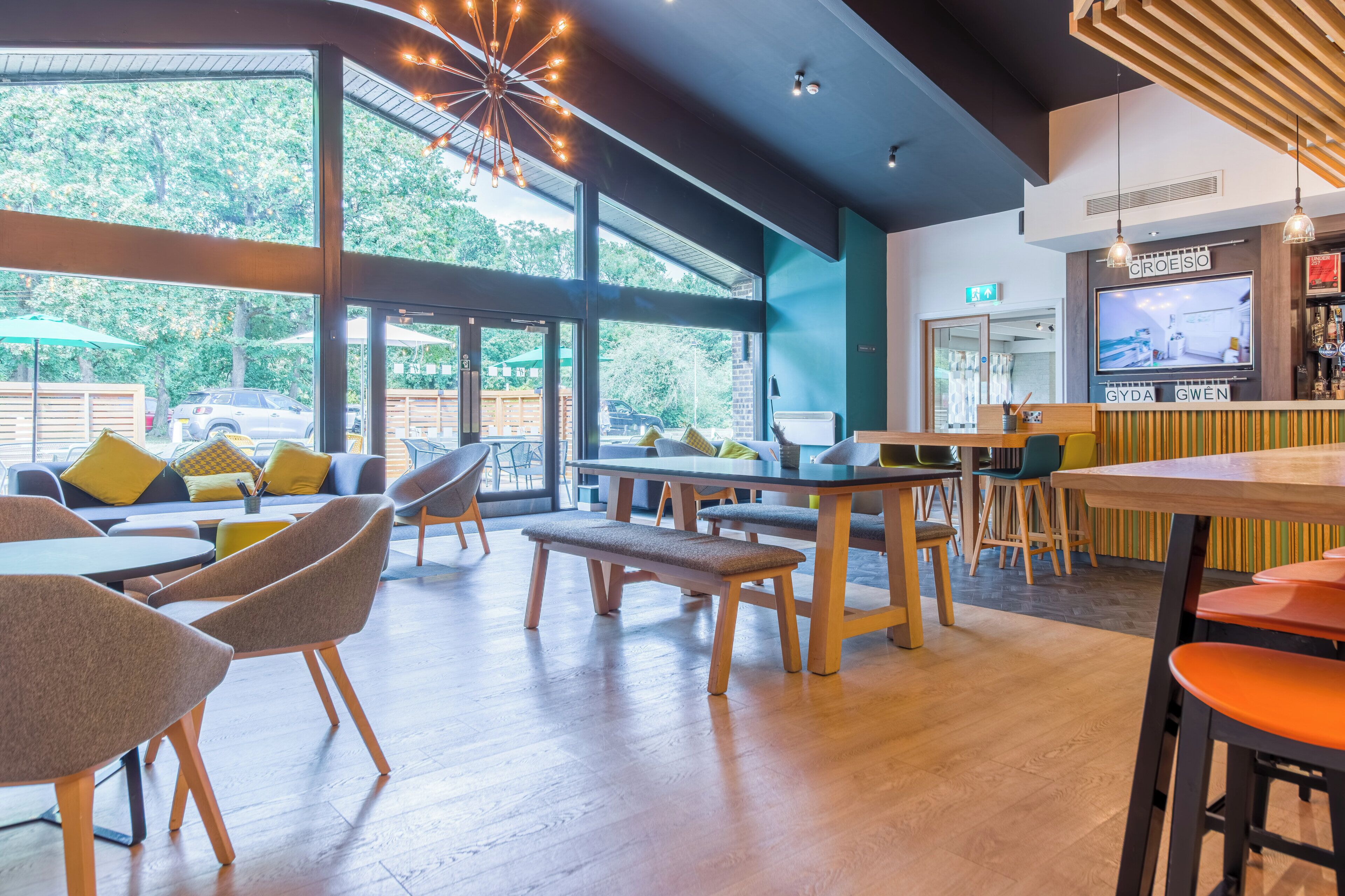 Un interior moderno con ventanas amplias, muebles de madera y una zona de bar.