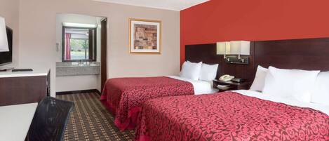 Een hotelkamer met twee bedden, een bureau, een stoel, een spiegel en een raam.