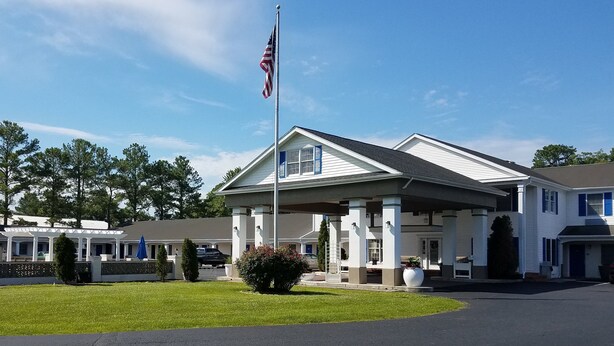 A two-story building with a covered entrance and an American flag. - St Michaels Inn (St. Michaels)