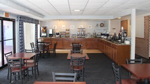 A restaurant with a bar area, multiple seating arrangements, and a kitchen visible in the background. - St Michaels Inn (St. Michaels)