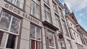 Ein Gebäude mit dem Schild "GOOD SEASONS", das auf ein Restaurant oder Café hinweist.