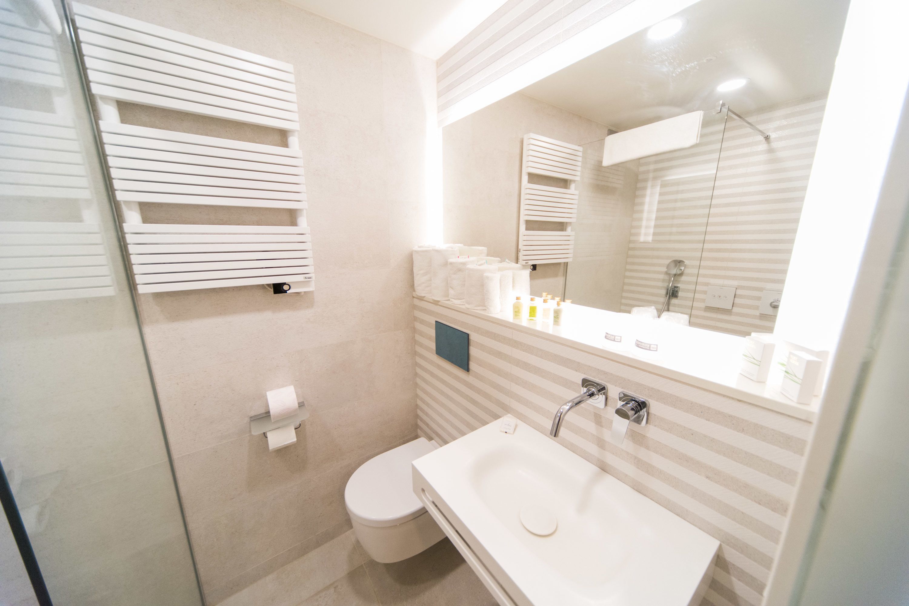 A modern bathroom with a toilet, sink, and shower.