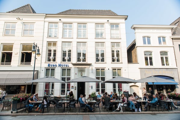 A hotel with outdoor seating and a sign reading "Euro Hotel".