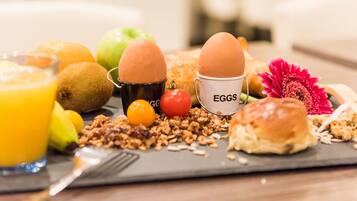A breakfast tray with eggs, fruits, and granola.