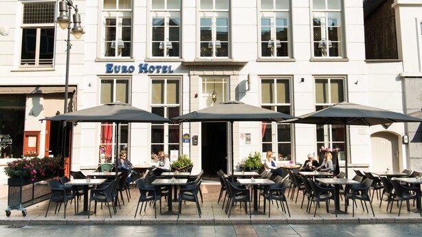 Ein Hotel mit Außenbereich und Sonnenschirmen.