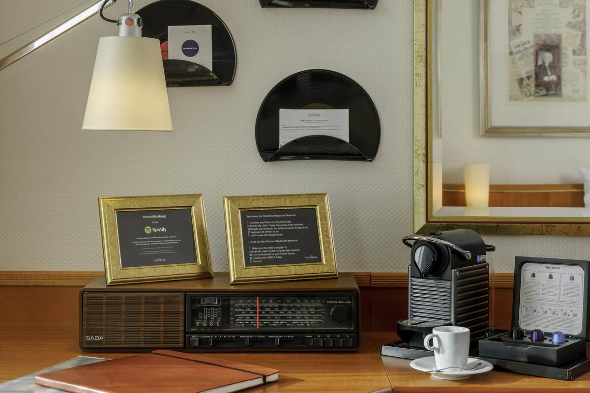 Une pièce avec un bureau en bois, une radio ancienne, un trophée encadré et des disques accrochés au mur.