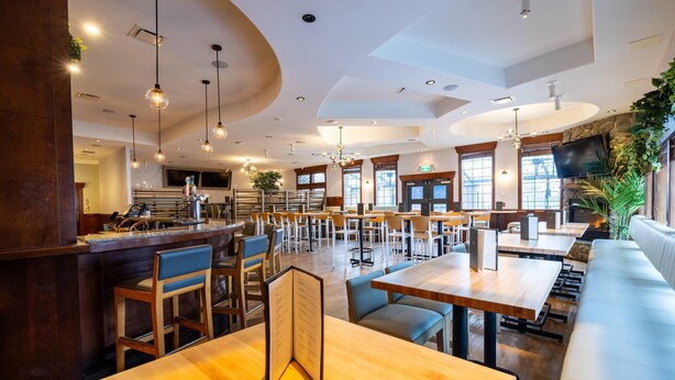 A spacious restaurant with high ceilings, pendant lighting, and a variety of seating options including tables and booths. - Sandman Hotel & Suites Prince George (Prince George)