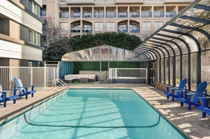 Una piscina al aire libre de temporada, sillones reclinables de piscina