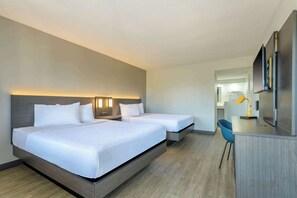 A hotel room with two beds, a desk, a chair, and a mirror. - Motel 6 Ocala, FL - Conference Center (Ocala)