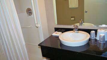 A bathroom with a white sink, a mirror, and a shower curtain.