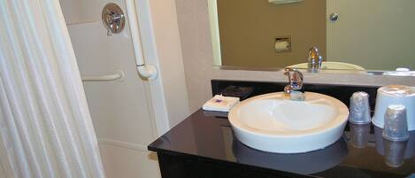 A bathroom with a white sink, a mirror, and a shower curtain.
