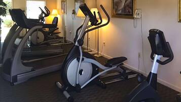 Ett hemmagym med en crosstrainer, en motionscykel och ett löpband.