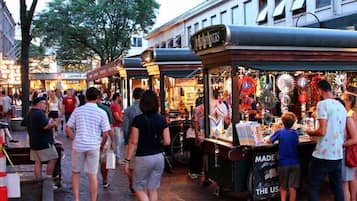 Een levendige straatmarkt met verschillende kraampjes en mensen die winkelen.