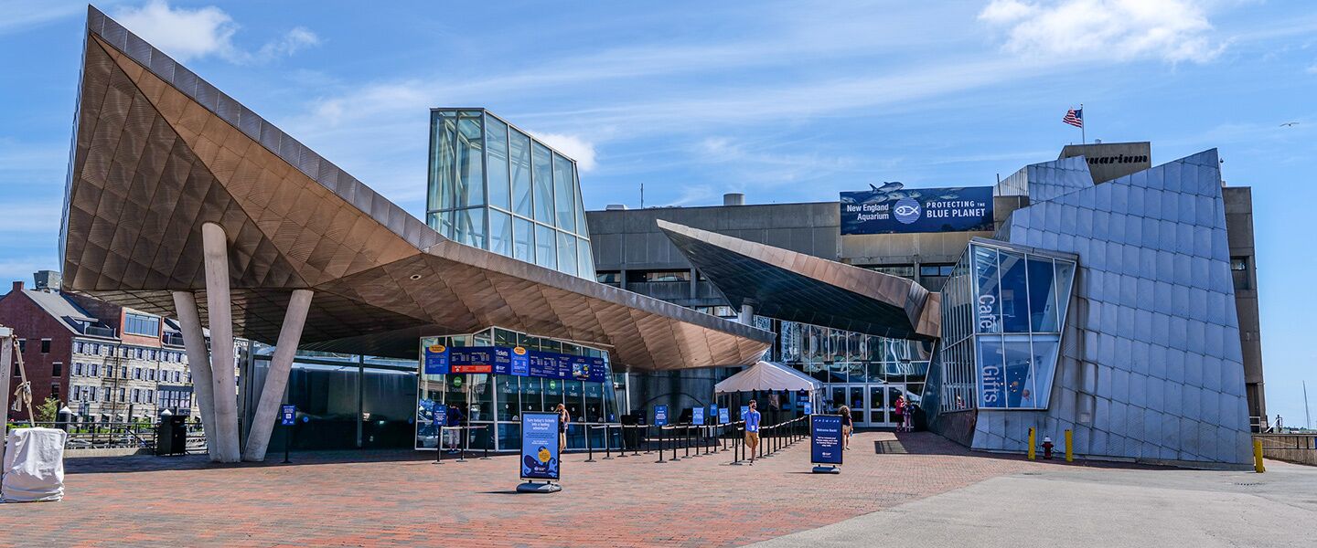 A modern building with a unique architectural design, featuring large glass windows and a prominent overhang structure.
