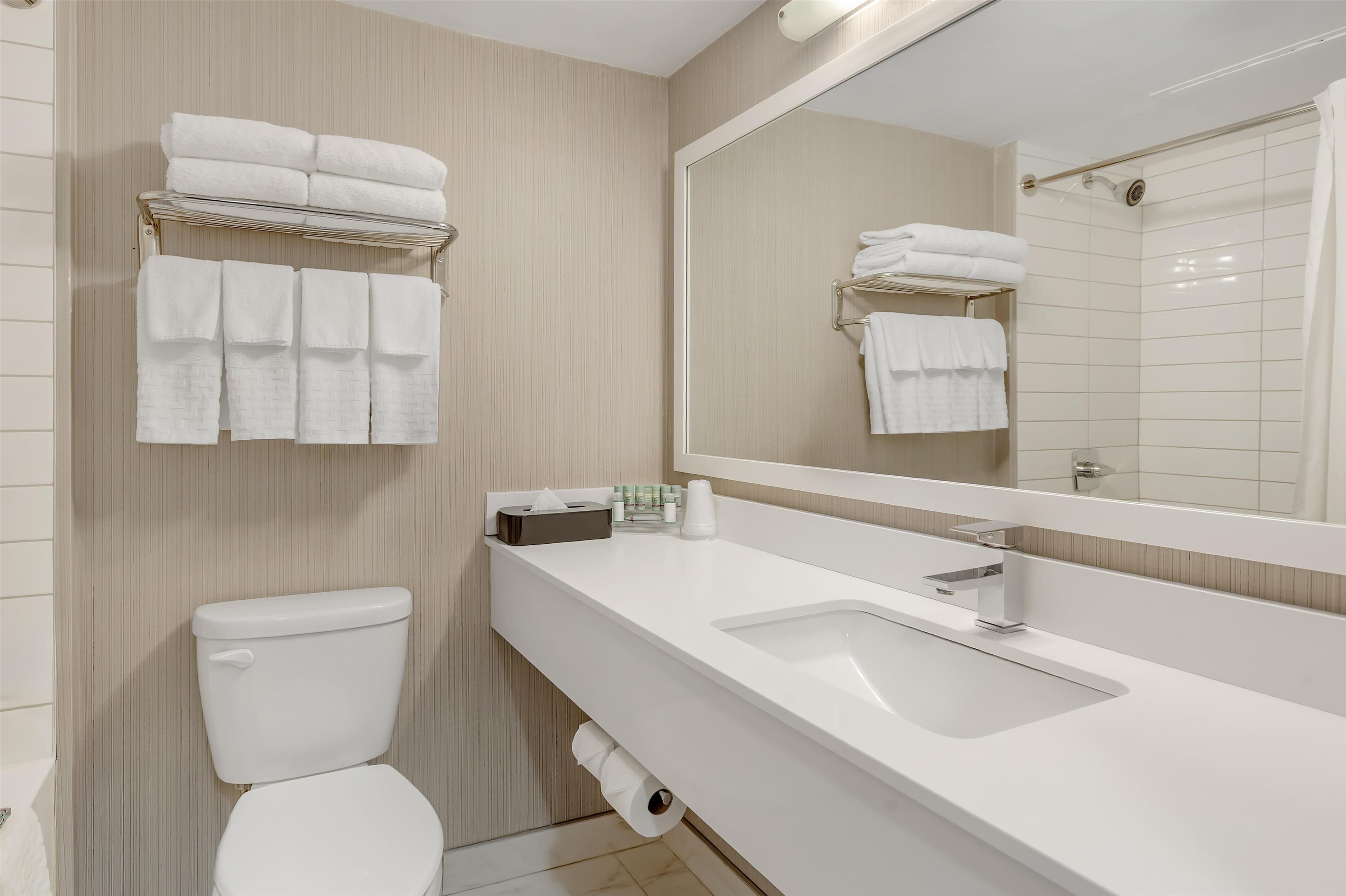 A modern bathroom with a toilet, sink, and towel rack.