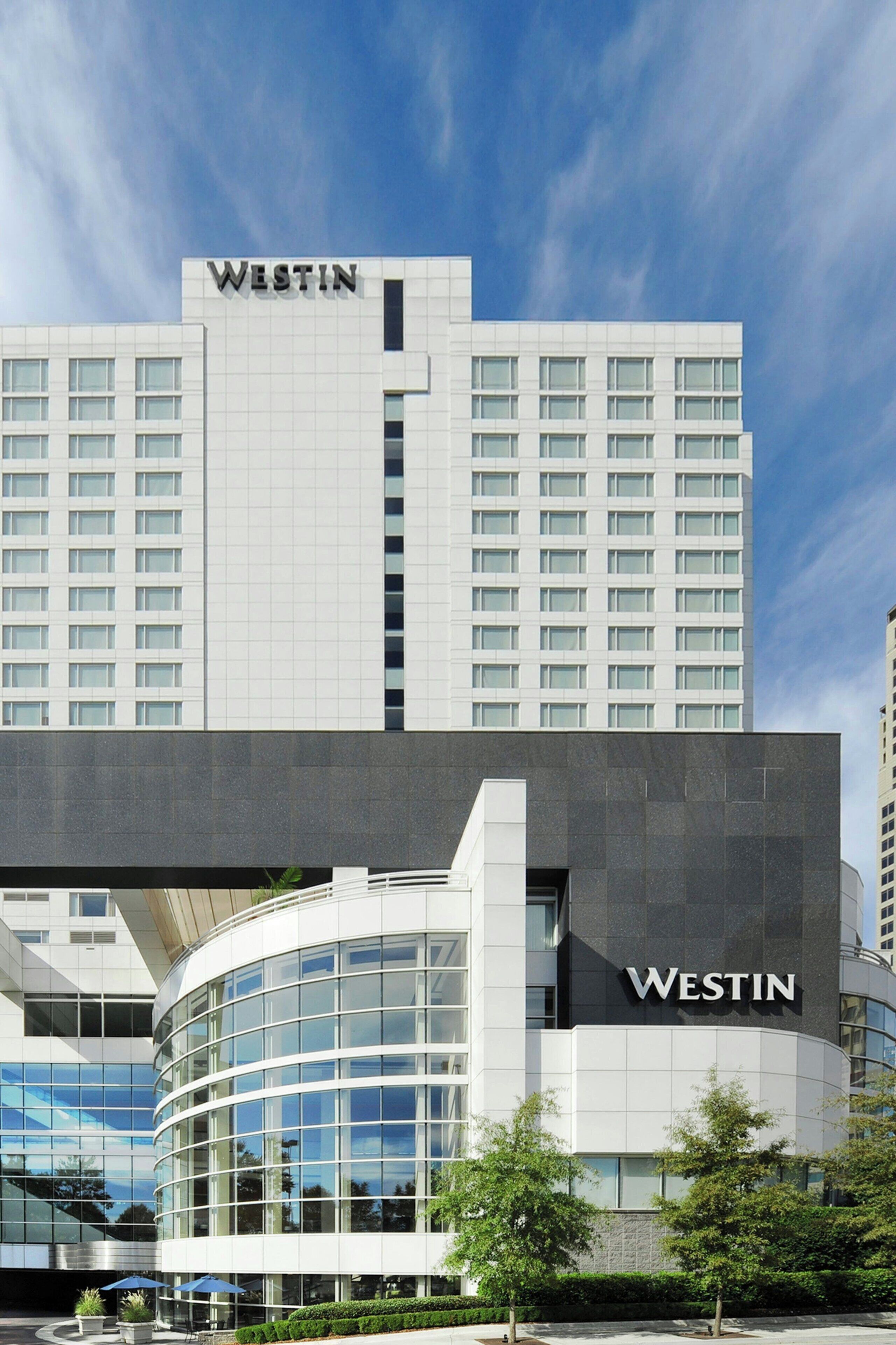A Westin hotel building with a modern glass facade and a prominent 'Westin' sign on the top.