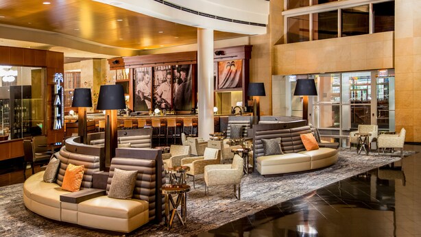 A spacious lobby with a curved seating area, a bar, and a staircase.