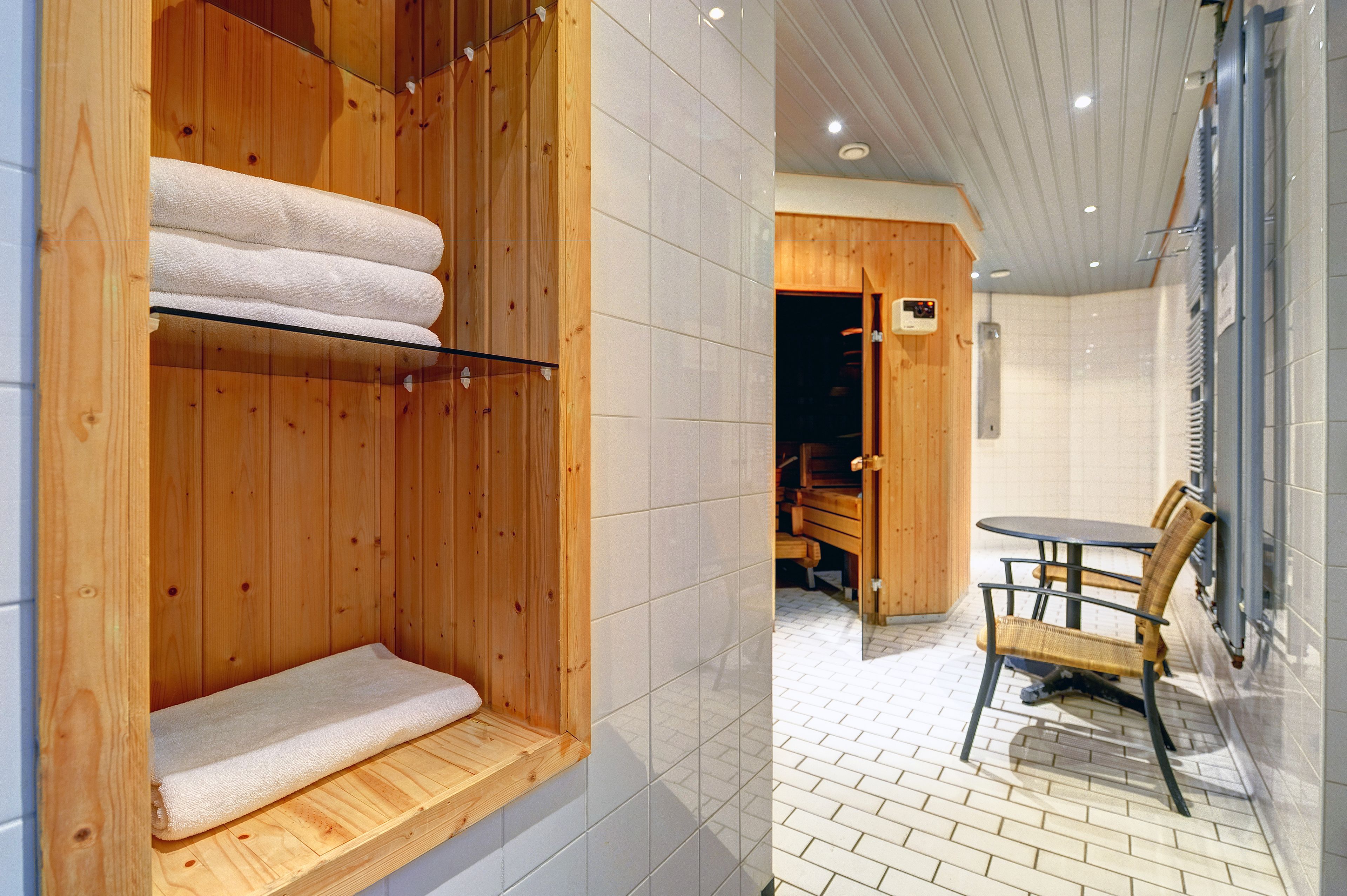A wooden sauna with a bench and a towel rack.
