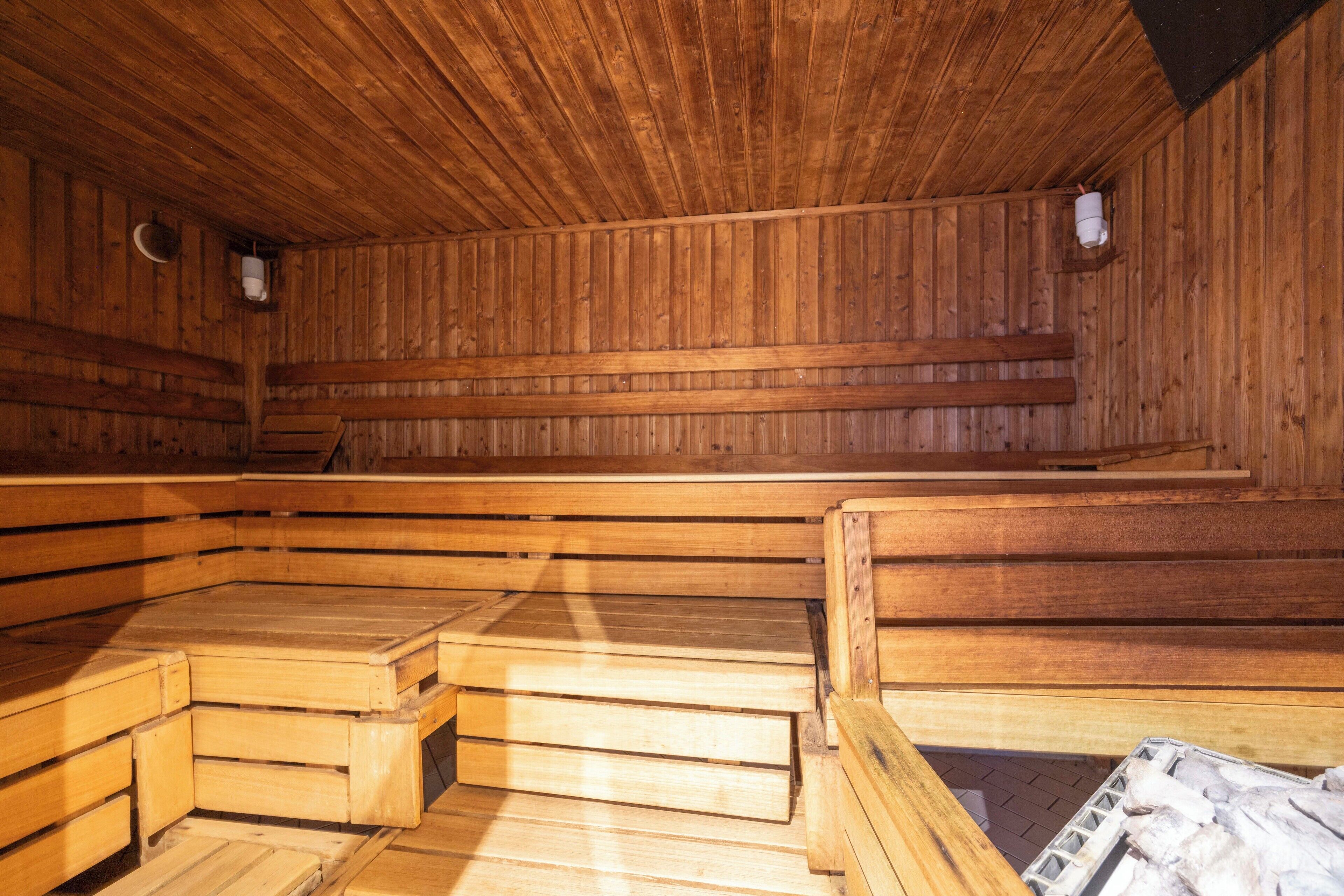 Een sauna met houten banken en wanden, en een betegelde vloer.