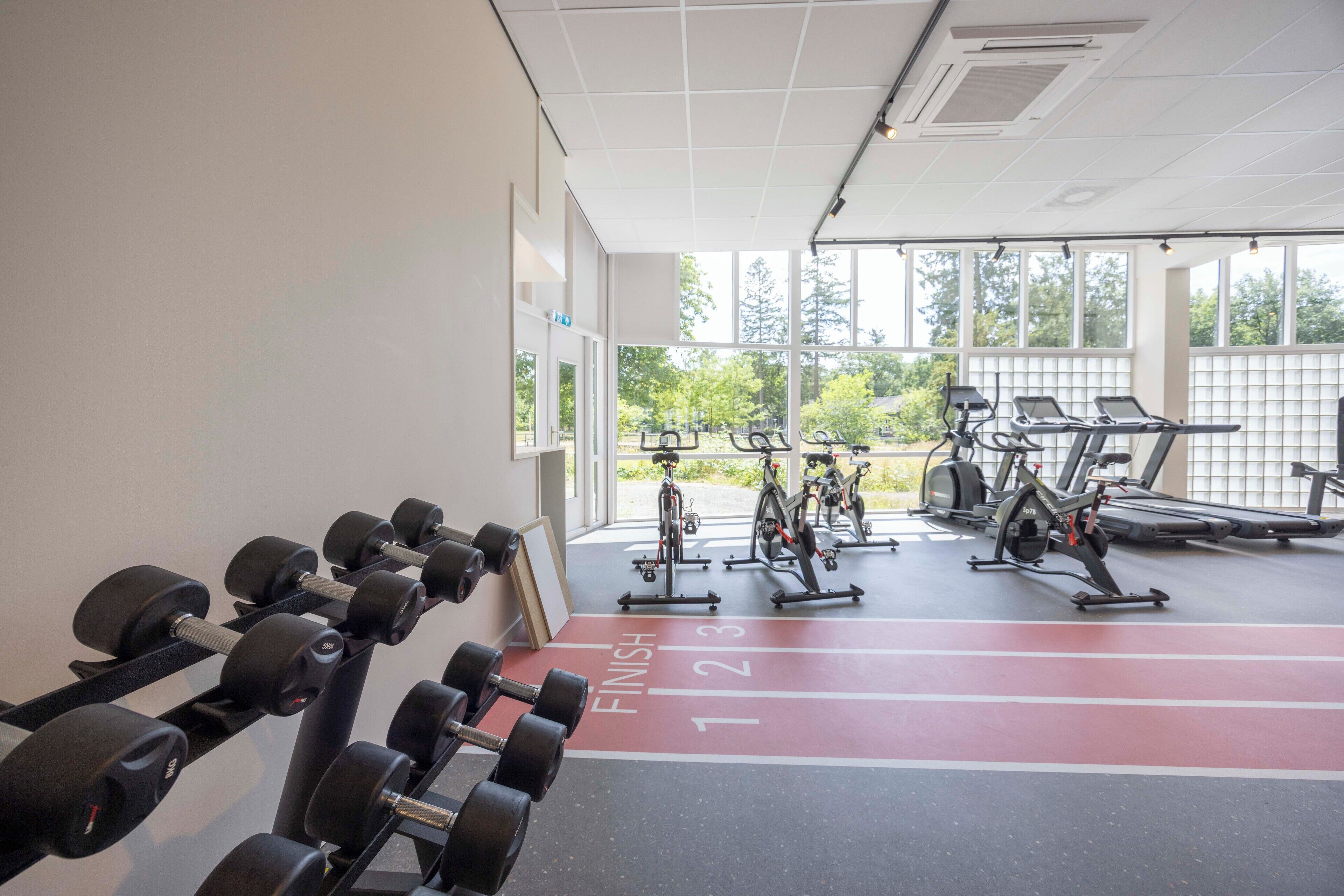Ein Fitnessstudio mit Laufbändern, Ergometer und Kurzhanteln.