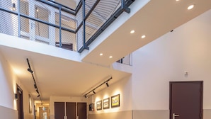 A spacious, modern interior with a high ceiling, a mezzanine level, and a wooden floor. - Fletcher Hotel - Restaurant Victoria - Hoenderloo (Hoenderloo)