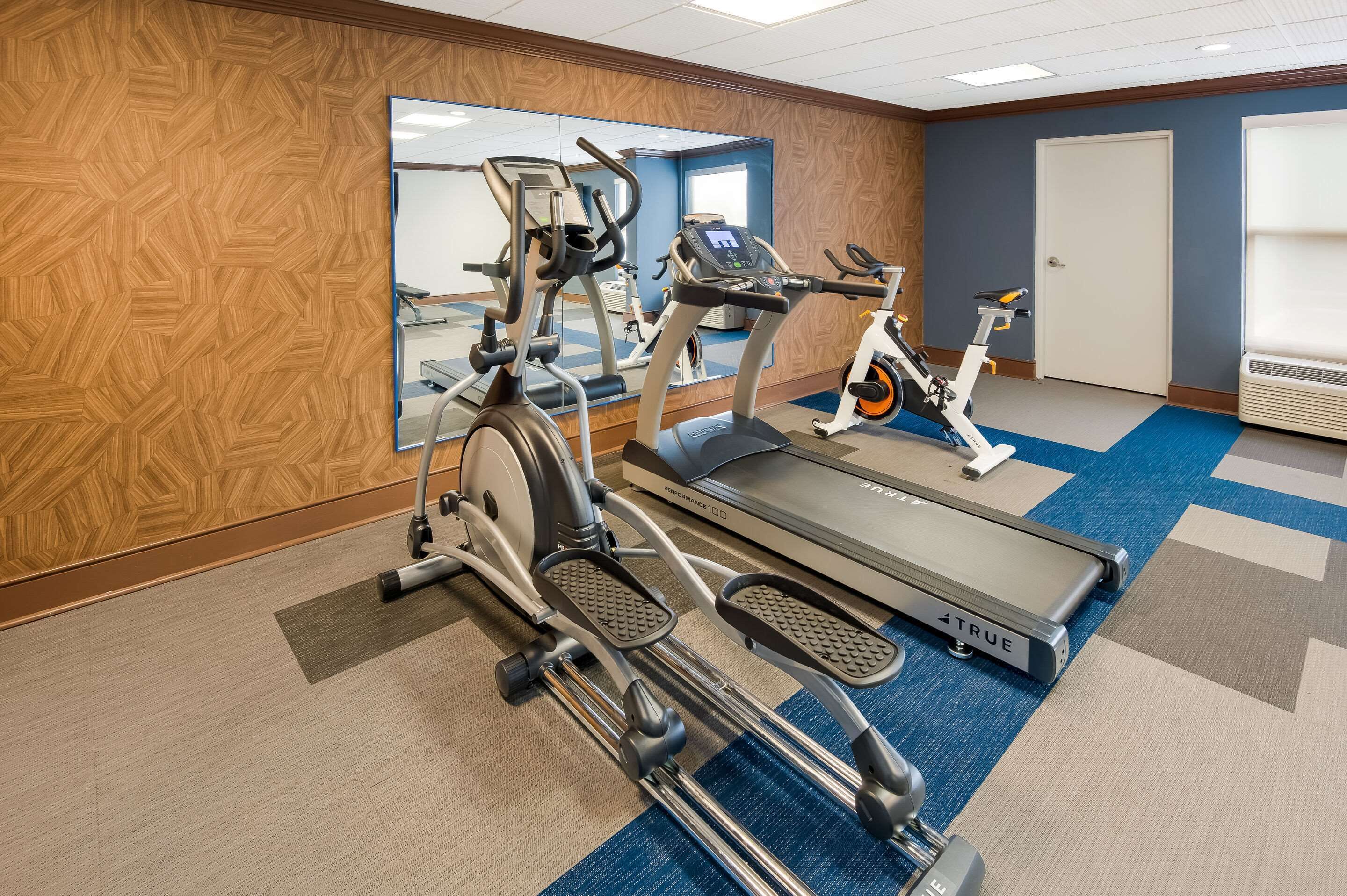 A gym with treadmills, an elliptical, and a stationary bike.