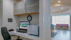 Ein modernes Büro mit Schreibtisch, Computer, Drucker und Stühlen.