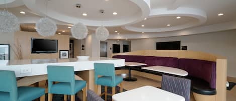 A modern interior with a bar area, seating, and a flat-screen TV.
