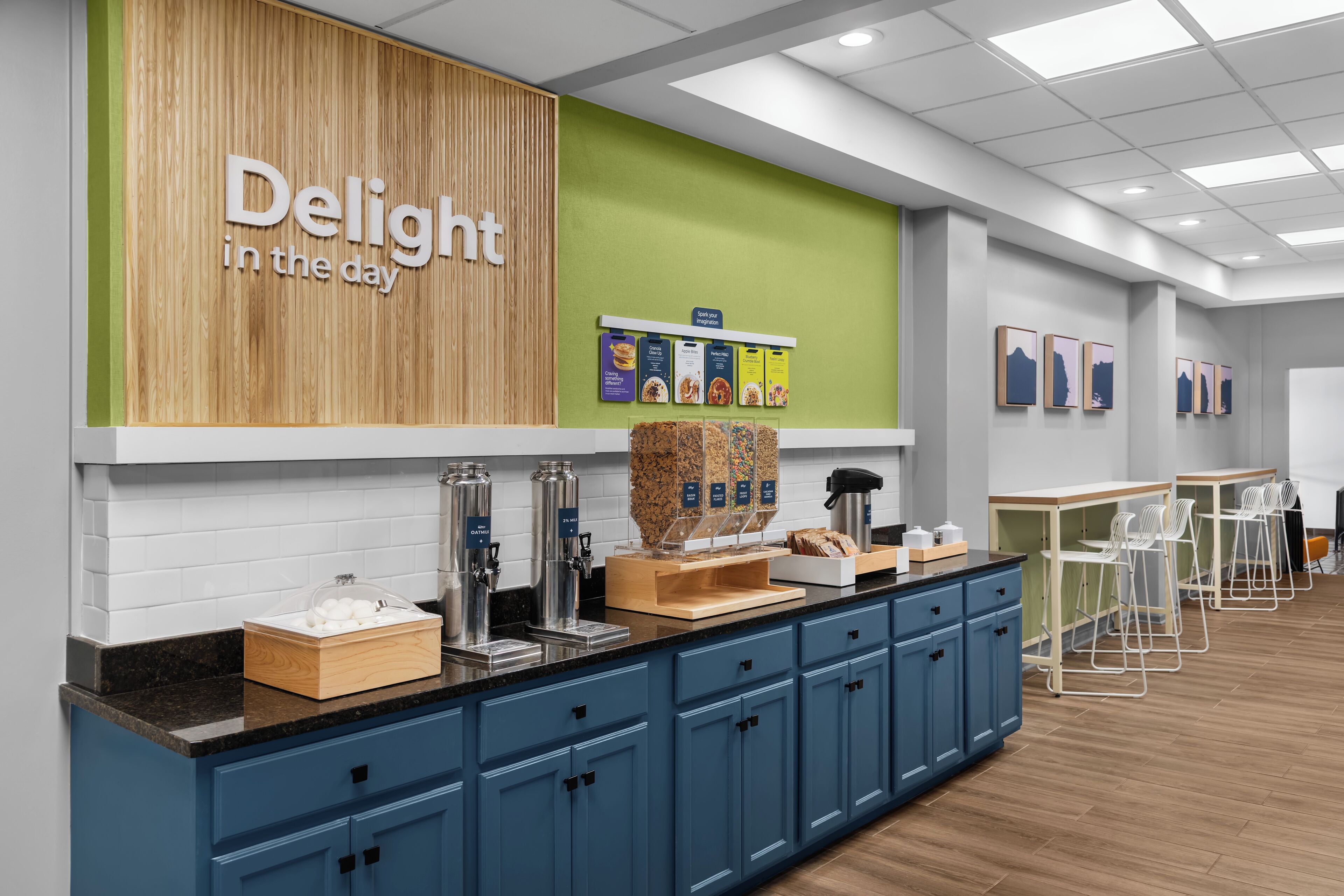 Una barra de desayuno con pared de madera, pared de acento verde y un letrero que dice 'Delight in the day'.
