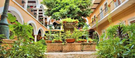 A courtyard with a central planter, surrounded by balconies and arches.