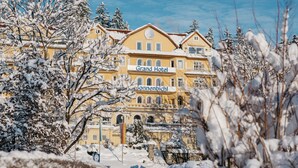 Een groot, geel gebouw met een bord waarop staat: ‘Grand Hotel Sonnenbichl’.