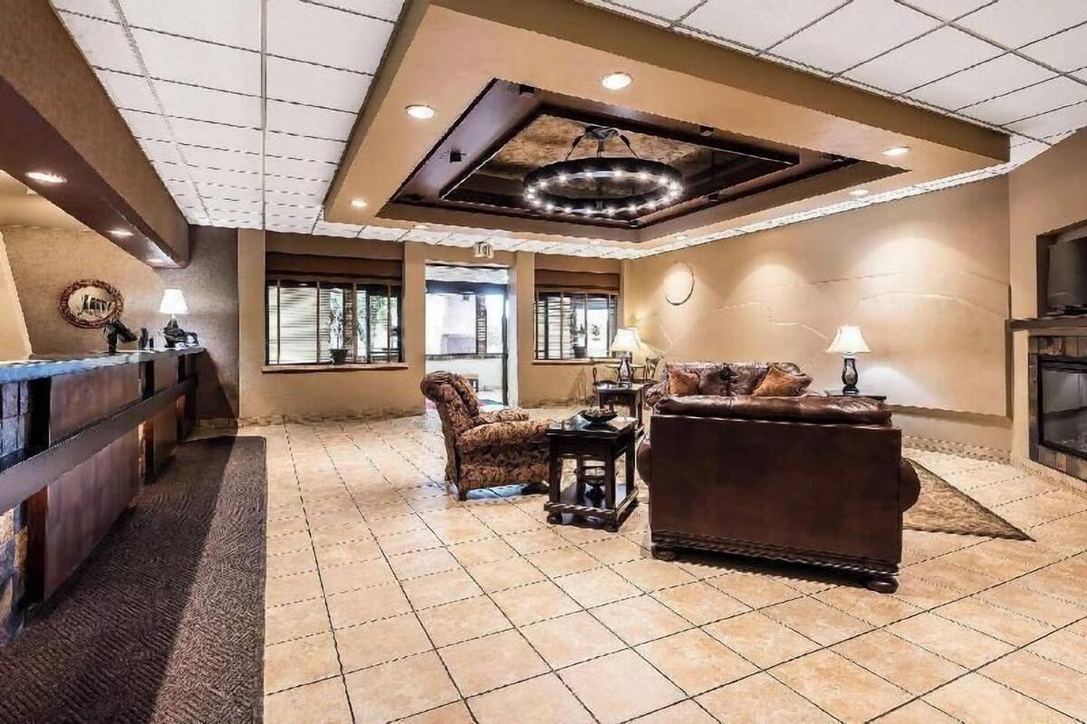 A spacious lobby with a reception desk, a sofa, a chair, and a fireplace.