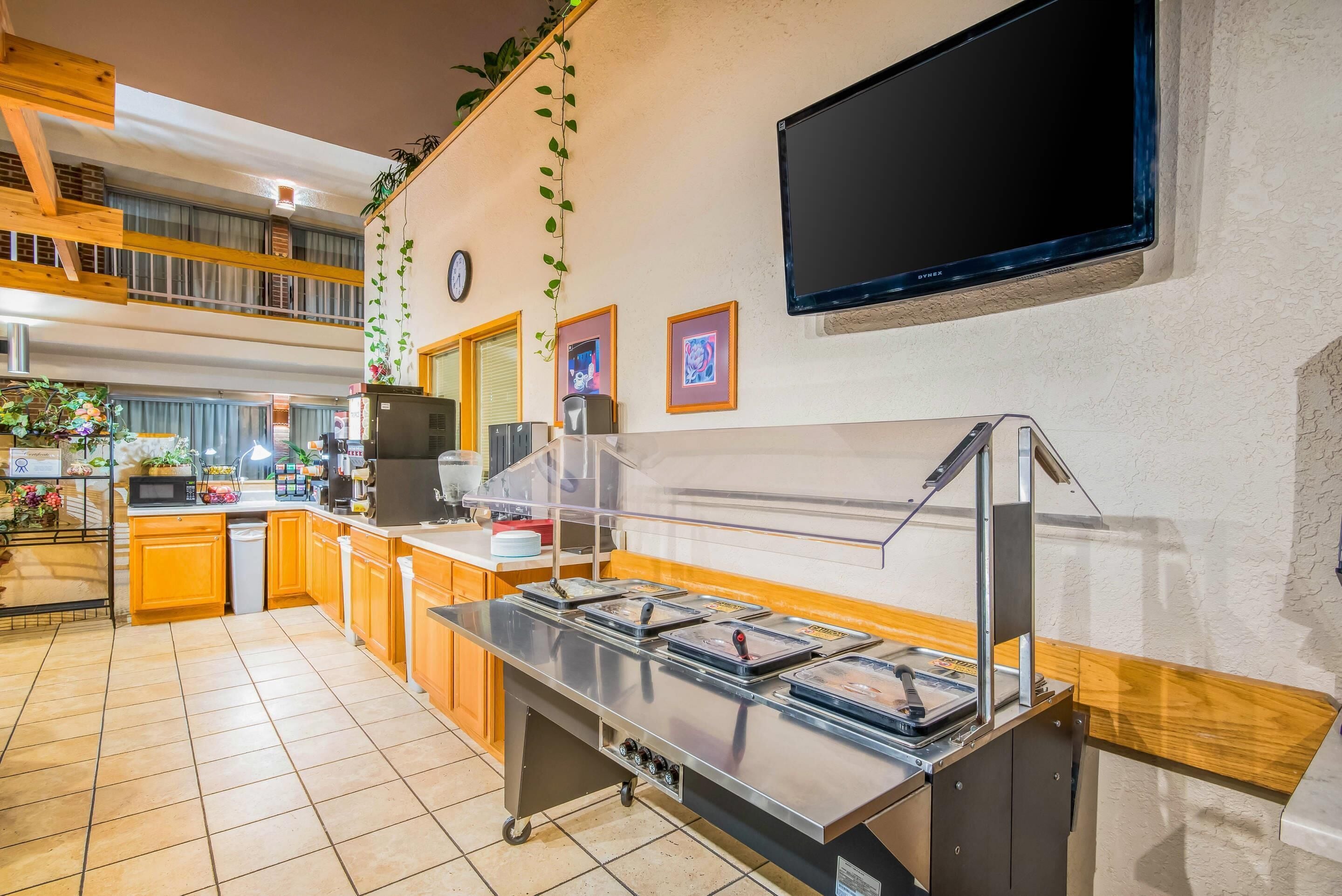 Una cocina moderna con un montaje tipo bufé, un televisor de pantalla plana y un reloj en la pared.