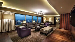 A modern living room with a city view, a sofa, armchairs, a coffee table, and a bookshelf. - Ankara HiltonSA (Ankara)