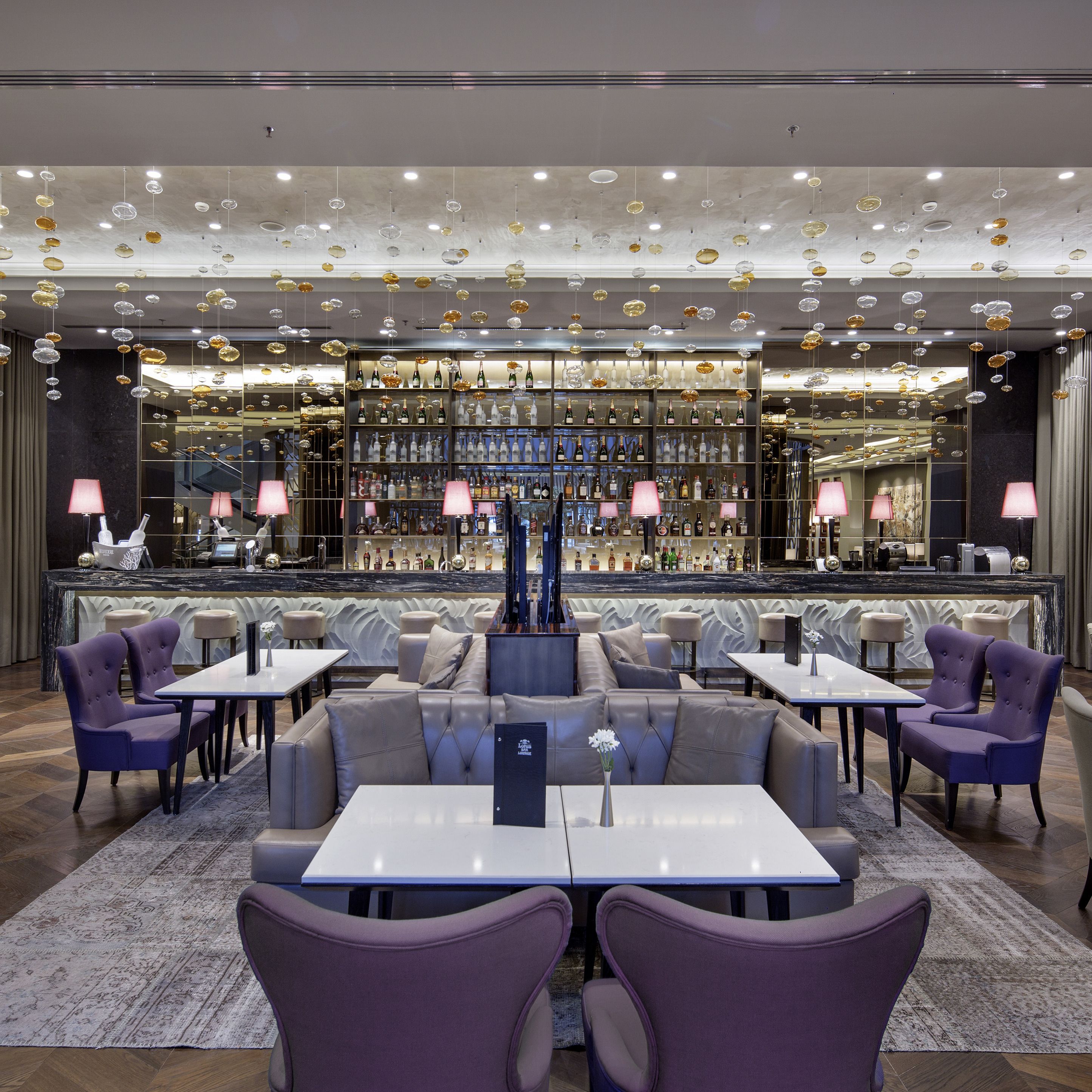 A modern bar area with seating and a wine display.
