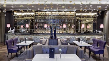 A modern bar area with seating and a wine display.