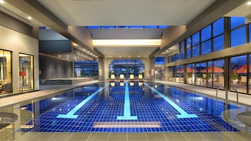 Alberca techada, sombrillas en la alberca y camastros