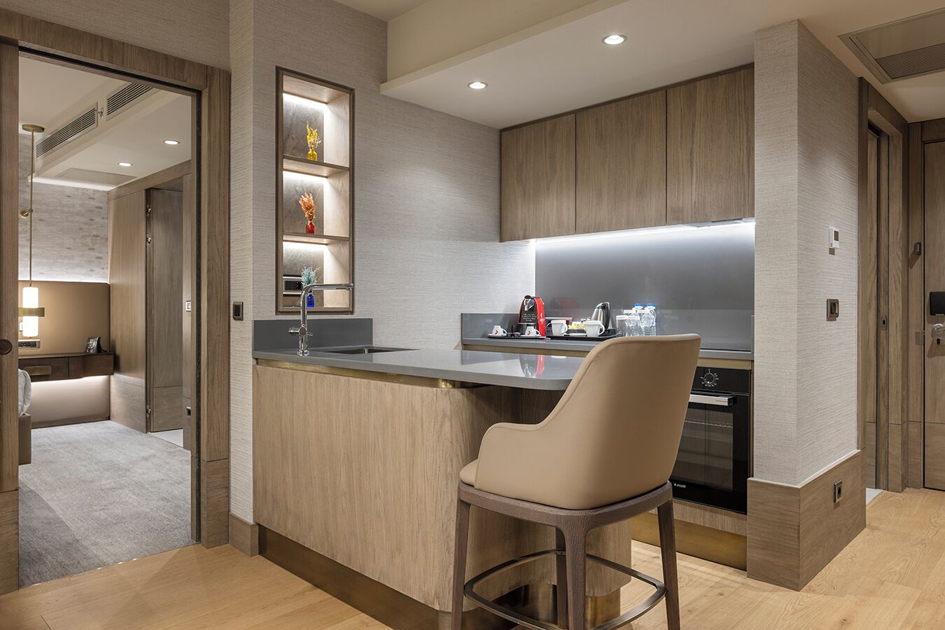 Een moderne keuken met een centraal eiland, barstoelen en inbouwapparatuur.