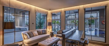 Una piscina techada, sombrillas, sillones reclinables de piscina