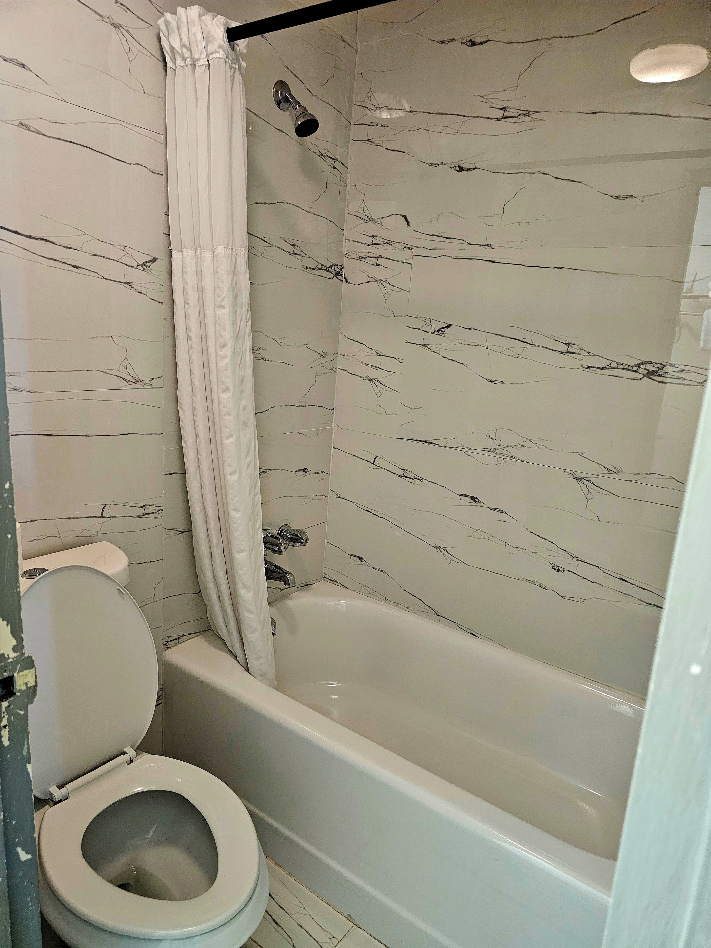 A bathroom with a toilet, a bathtub, and a shower curtain.