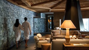 Un área de spa con paredes de piedra, muebles de madera y una lámpara grande.