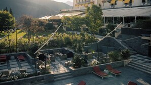 Un patio de hotel con sillones de sol, una escalera de piedra y vistas a las montañas.