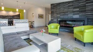 A modern living room with a sectional sofa, a white coffee table, and two bright yellow armchairs.