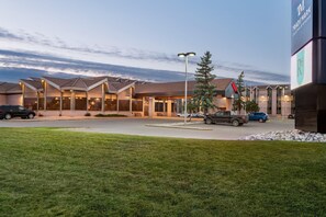 A hotel with multiple connected buildings, a parking lot, and a grassy area in front. - Royal Hotel West Edmonton, Trademark Collection by Wyndham (Edmonton)