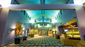 A hotel lobby with a check-in counter, seating area, and a bar. - Royal Hotel West Edmonton, Trademark Collection by Wyndham (Edmonton)