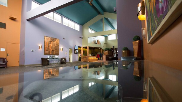 A spacious lobby with a high ceiling, a reception desk, and a large mirror. - Royal Hotel West Edmonton, Trademark Collection by Wyndham (Edmonton)